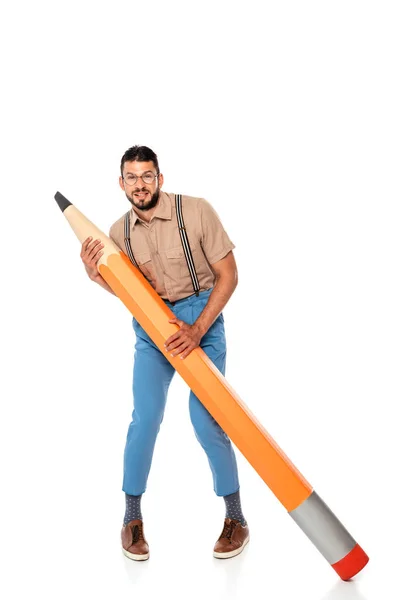 Beau nerd dans les bretelles tenant un énorme crayon sur fond blanc — Photo de stock