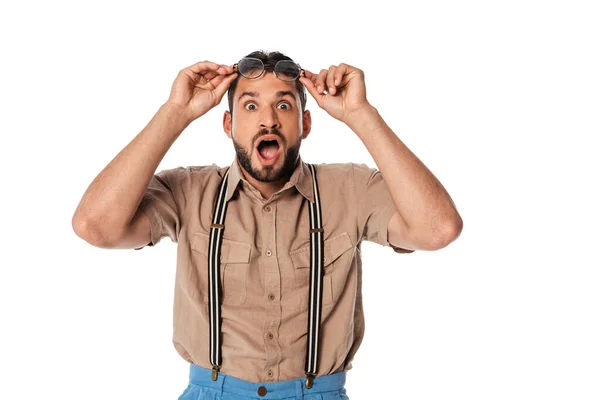 Shocked nerd holding eyeglasses and looking at camera isolated on white — Stock Photo