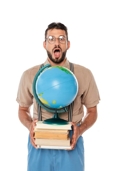 Shocked nerd looking at camera while holding globe and books isolated on white — Stock Photo