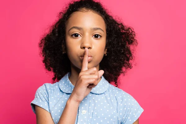 Cute curly african american kid showing shh sign isolated on pink — Stock Photo