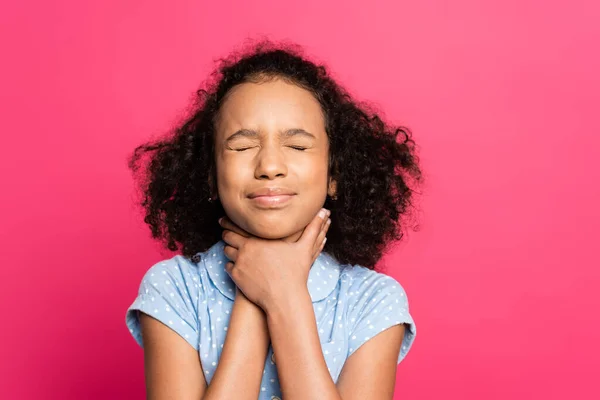 Frisé afro-américain gosse avec les yeux fermés et les mains sur la gorge isolé sur rose — Photo de stock