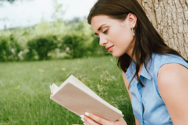 Bella giovane donna lettura libro al di fuori — Foto stock