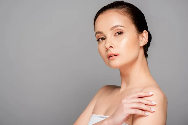 Beautiful woman with perfect skin looking at camera isolated on grey — Stock Photo