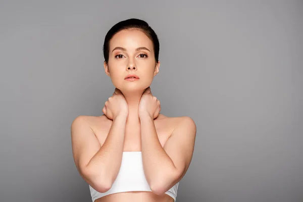 Beautiful woman with perfect skin touching neck isolated on grey — Stock Photo