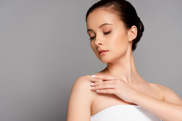 Bella donna con pelle perfetta spalla toccante isolato su grigio — Foto stock