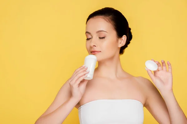 Bela mulher nua cheirando desodorizante vara isolado no amarelo — Fotografia de Stock