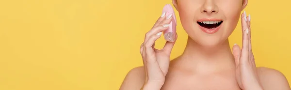 Cropped view of shocked beautiful naked woman holding facial cleansing brush isolated on yellow, panoramic shot — Stock Photo