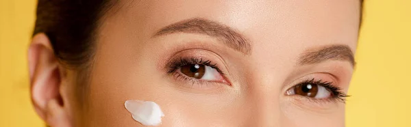 Cropped view of woman with cosmetic cream on face isolated on yellow, panoramic shot — Stock Photo