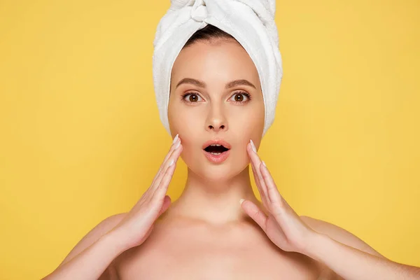 Shocked beautiful naked woman with towel on head isolated on yellow — Stock Photo