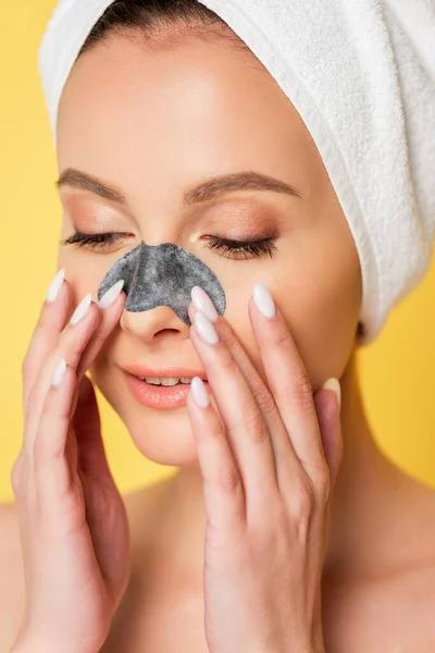 Beautiful naked woman with towel on head and blackhead remover on  nose isolated on yellow — Stock Photo