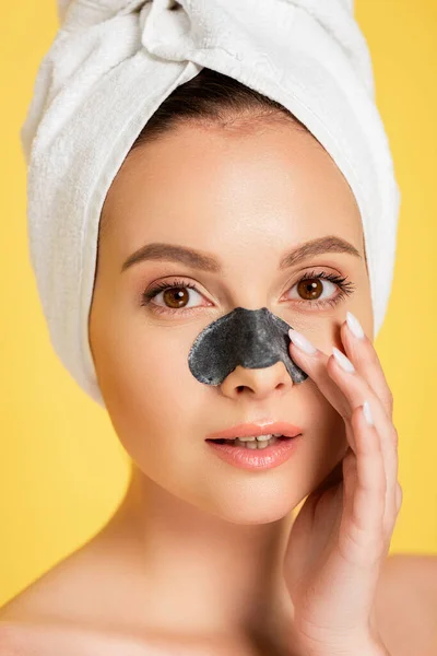 Bela mulher nua com toalha na cabeça e removedor blackhead no nariz isolado no amarelo — Fotografia de Stock