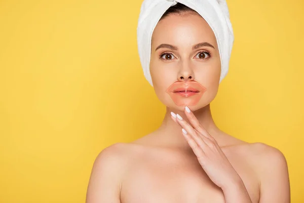 Naked beautiful woman with towel on head, lip patch isolated on yellow — Stock Photo