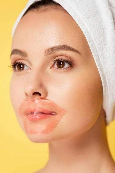 Bella donna con asciugamano sulla testa, patch labbro isolato su giallo — Foto stock