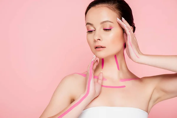Beautiful woman with pink lines on body and hands near face isolated on pink — Stock Photo