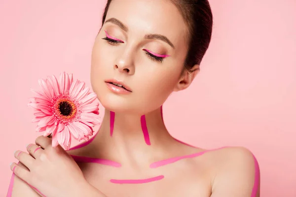 Hermosa mujer desnuda con líneas de color rosa en el cuerpo y crisantemo aislado en rosa - foto de stock