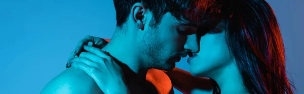Панорамний знімок сексуальної пари цілується ізольовано на синьому — стокове фото