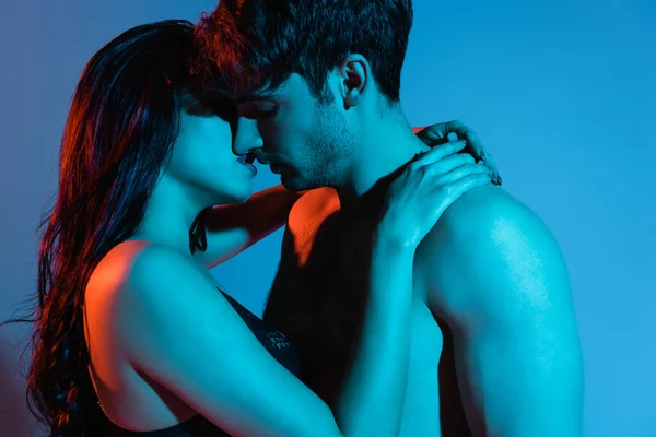 Young and sexy couple kissing and hugging on blue — Stock Photo