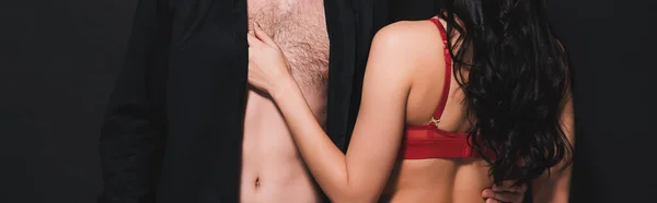 Горизонтальный урожай страстной женщины, касающейся мужчины, изолированного на черном — стоковое фото