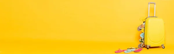Borsa da viaggio con infradito colorate su sfondo giallo, scatto panoramico — Foto stock