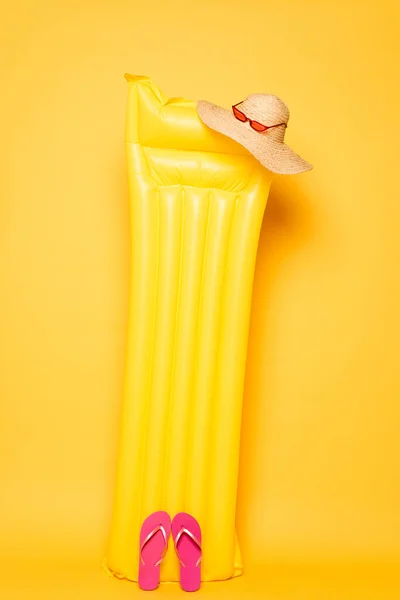 Flotteur de piscine avec accessoires de plage sur fond jaune — Photo de stock