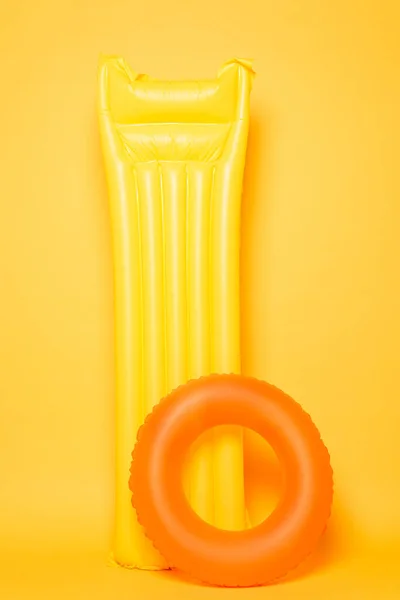 Piscina galleggiante e anello di nuoto su sfondo giallo — Foto stock