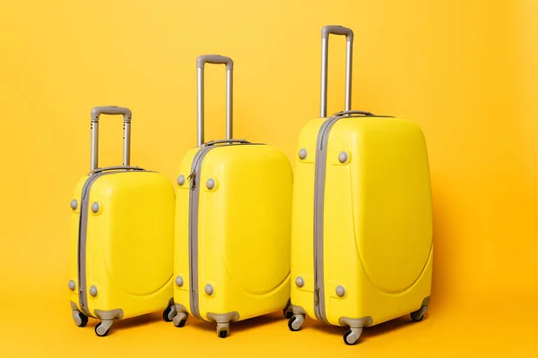 Pila de bolsas de viaje sobre fondo amarillo - foto de stock