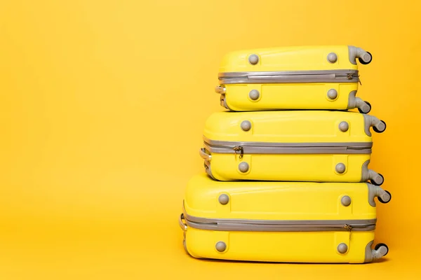 Pila de bolsas de viaje sobre fondo amarillo - foto de stock