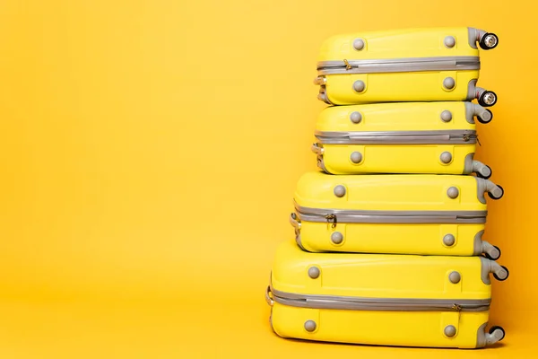 Pile de sacs de voyage sur fond jaune — Photo de stock