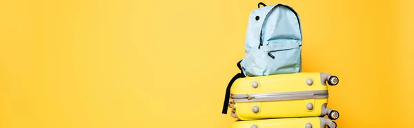 Blue backpack on travel bags isolated on yellow, panoramic shot — Stock Photo
