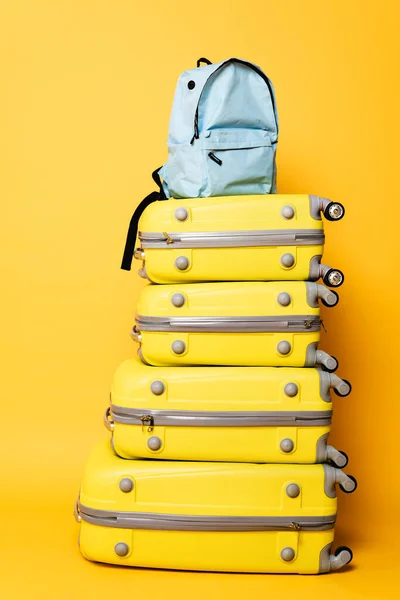 Blue backpack on travel bags on yellow background — Stock Photo