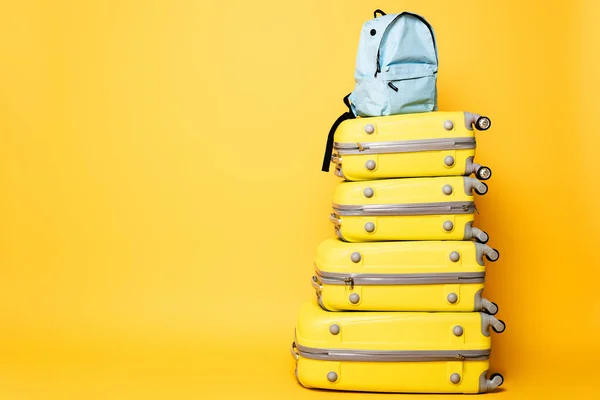 Mochila azul en bolsas de viaje aisladas en amarillo - foto de stock
