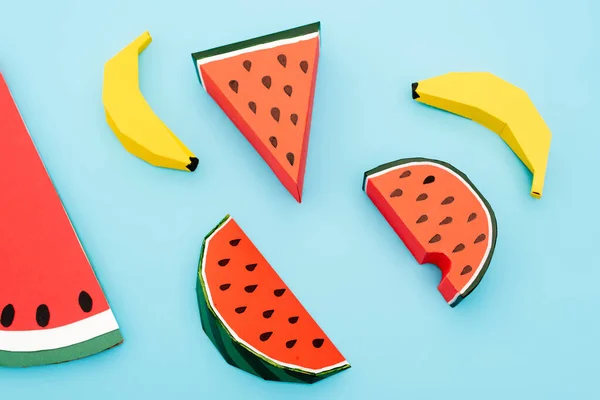 Wassermelone und Bananen aus Papier auf blauem Hintergrund — Stockfoto