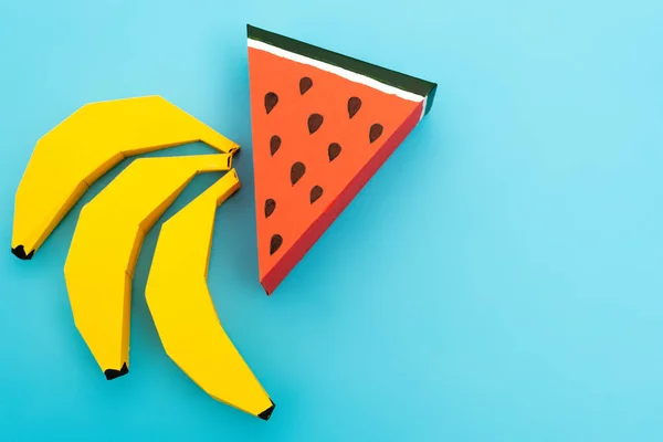 Wassermelone und Bananen aus Papier auf blauem Hintergrund — Stockfoto