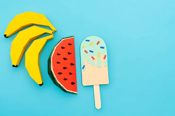 Draufsicht auf Papier Wassermelone, Bananen und Eis mit Streusel auf blauem Hintergrund — Stockfoto