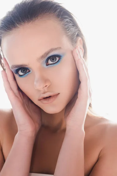 Schöne junge Frau mit Make-up berührt Schläfen und schaut in die Kamera isoliert auf weiß — Stockfoto