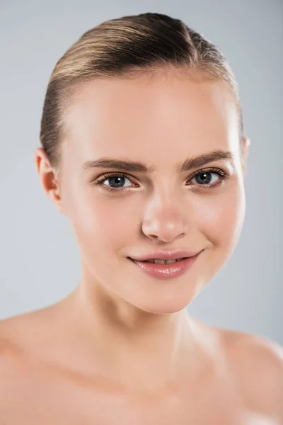 Happy young woman smiling and looking at camera isolated on grey — Stock Photo