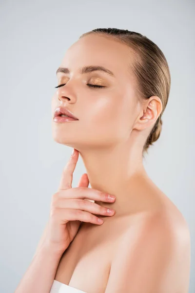 Pretty woman with closed eyes touching neck isolated on grey — Stock Photo