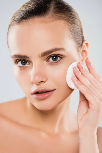 Naked woman holding cotton pad near clean face isolated on grey — Stock Photo