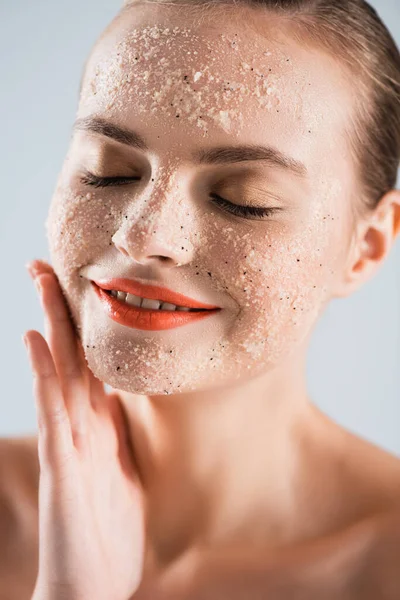 Primo piano di felice giovane donna applicare scrub isolato su bianco — Foto stock