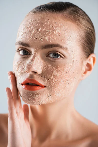 Close up de nu jovem mulher aplicando scrub isolado no branco — Fotografia de Stock