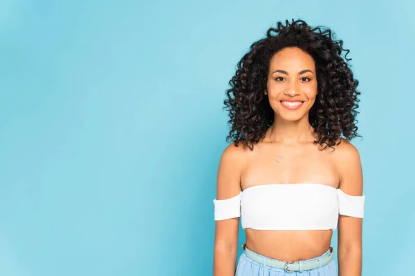 Feliz afroamericano chica mirando cámara aislada en azul - foto de stock