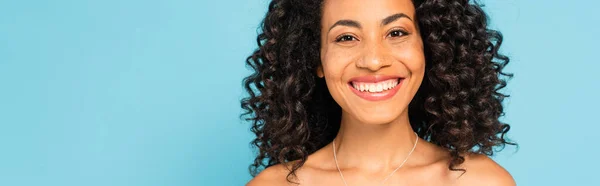 Cosecha horizontal de feliz afroamericano chica sonriendo aislado en azul - foto de stock