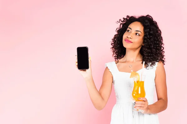 Encaracolado menina americana africana segurando smartphone com tela em branco e coquetel em rosa — Fotografia de Stock