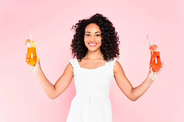 Glücklich afrikanisch-amerikanische Mädchen hält Cocktails auf rosa — Stockfoto