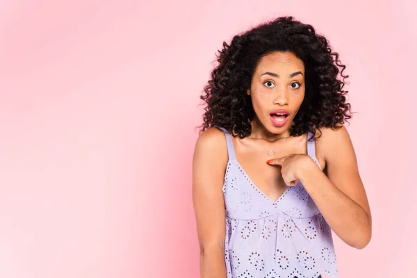 Shocked african american girl pointing with finger at herself isolated on pink — Stock Photo