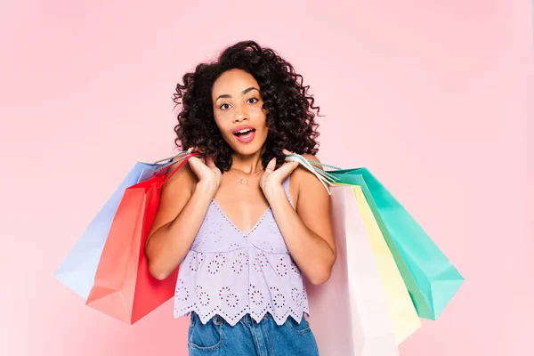 Überrascht afrikanisch-amerikanische Mädchen mit Einkaufstaschen isoliert auf rosa — Stockfoto