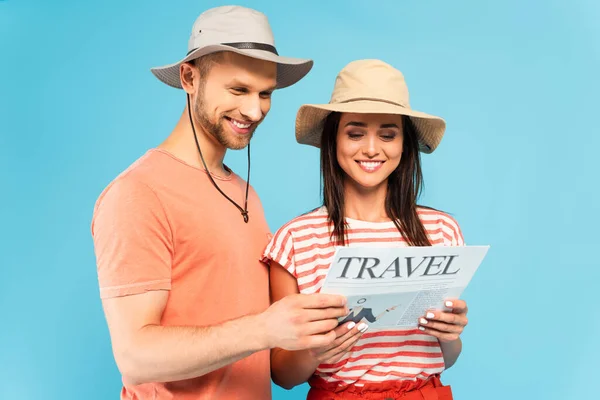 Casal feliz ler jornal de viagem isolado no azul — Fotografia de Stock