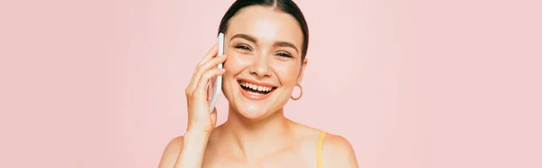 Brunette young woman talking on smartphone isolated on pink, panoramic shot — Stock Photo