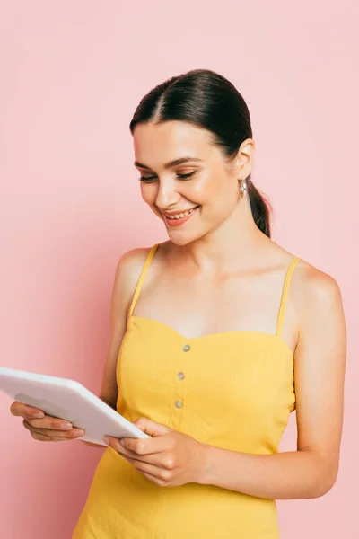Brunette young woman using digital tablet on pink — Stock Photo