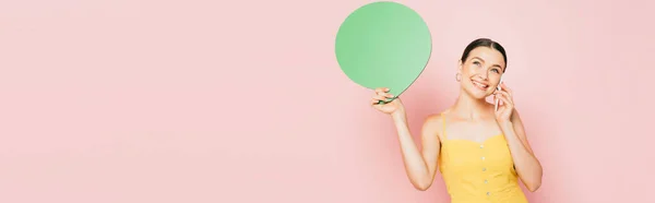 Morena mujer joven con verde burbuja habla en blanco hablando en el teléfono inteligente en rosa, tiro panorámico - foto de stock